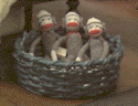 three sock monkeys in a basket